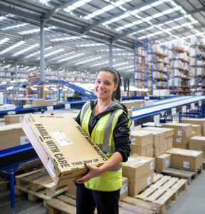 Pick, Wrap, Label Picture of warehouse work holding parcel